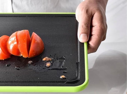 Person holding a double-sided green chopping board with sliced tomatoes, showcasing non-slip and easy-clean features.